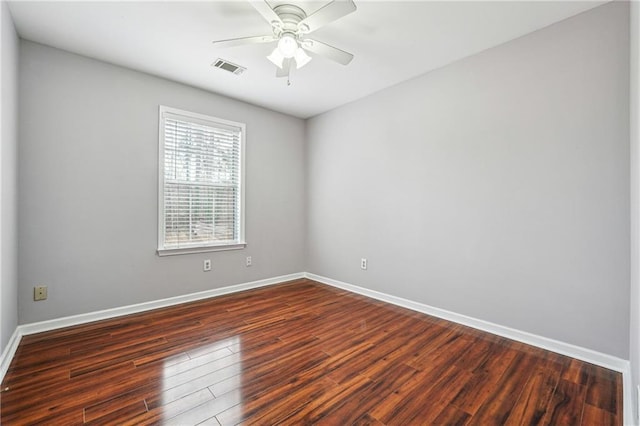 empty room with visible vents, baseboards, dark wood-style floors, and a ceiling fan