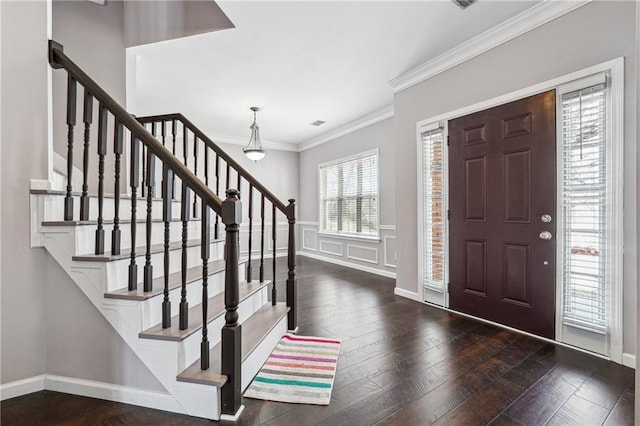 foyer entrance with ornamental molding, hardwood / wood-style flooring, a decorative wall, baseboards, and stairs