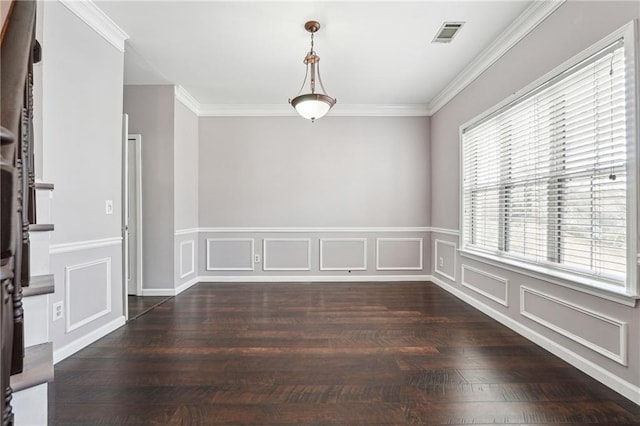 unfurnished room featuring visible vents, ornamental molding, a decorative wall, and wood finished floors