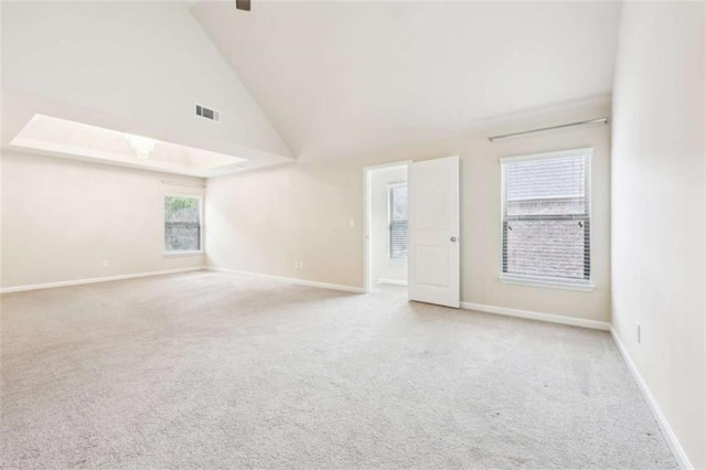 spare room with light colored carpet and high vaulted ceiling