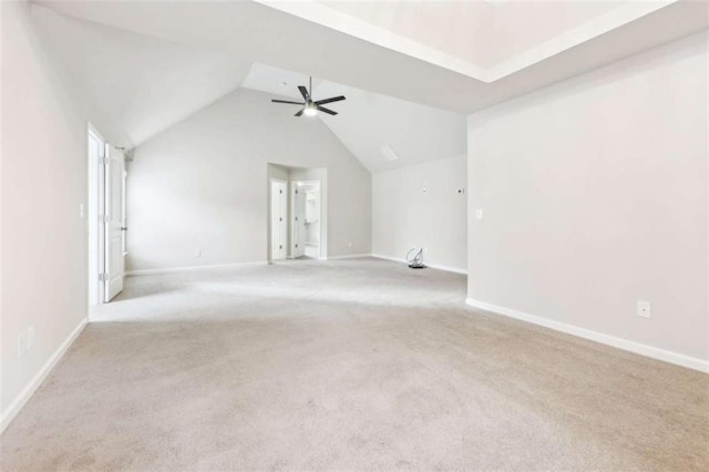 empty room featuring light carpet, vaulted ceiling, and ceiling fan