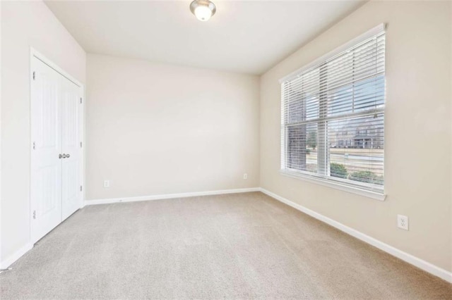 spare room featuring light colored carpet and plenty of natural light