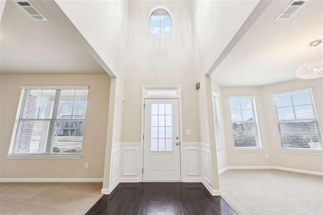 entryway featuring dark hardwood / wood-style floors, an inviting chandelier, and plenty of natural light