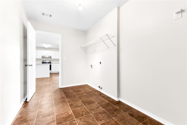 clothes washing area featuring dark tile patterned floors and electric dryer hookup