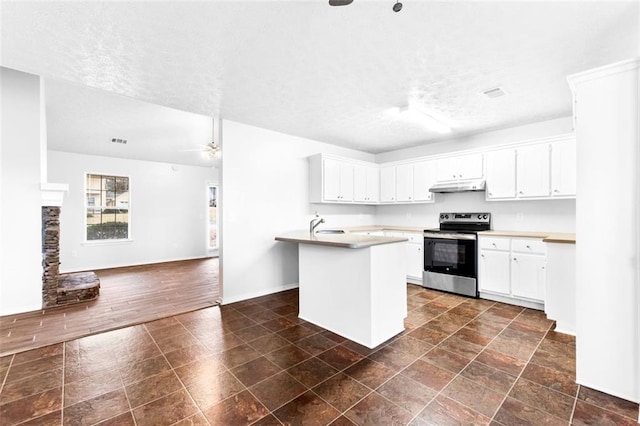 kitchen with a textured ceiling, a center island with sink, ceiling fan, stainless steel electric stove, and white cabinets