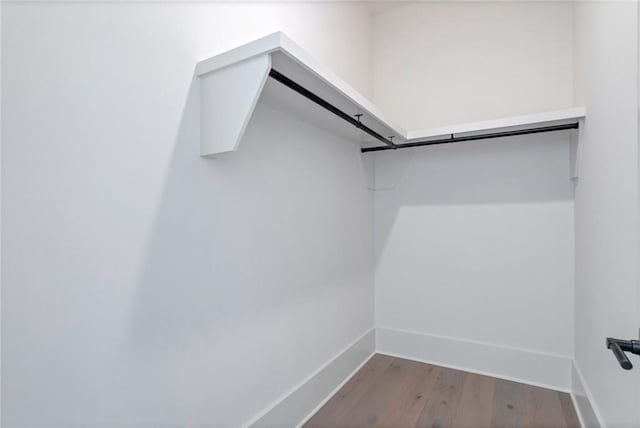 walk in closet with light hardwood / wood-style floors