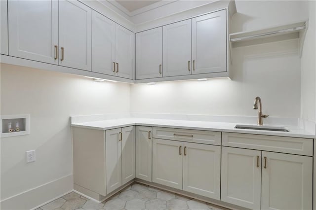washroom with hookup for a washing machine, sink, and cabinets