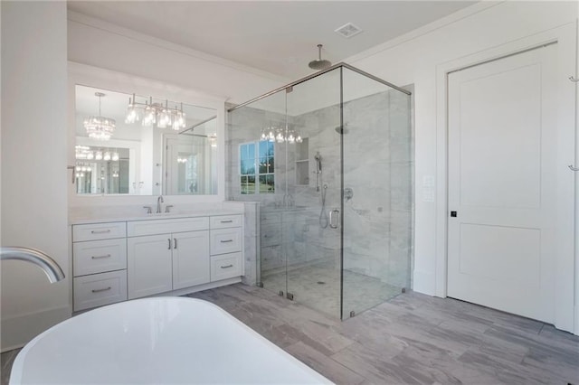 bathroom with vanity, a shower with shower door, ornamental molding, and an inviting chandelier