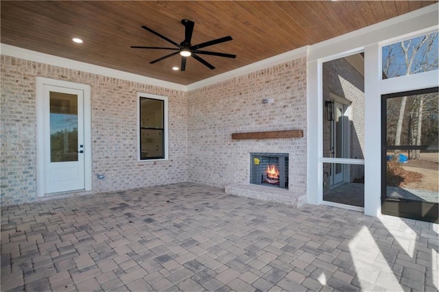 view of patio featuring an outdoor brick fireplace and ceiling fan