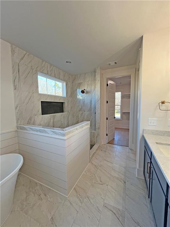 bathroom featuring plus walk in shower and vanity