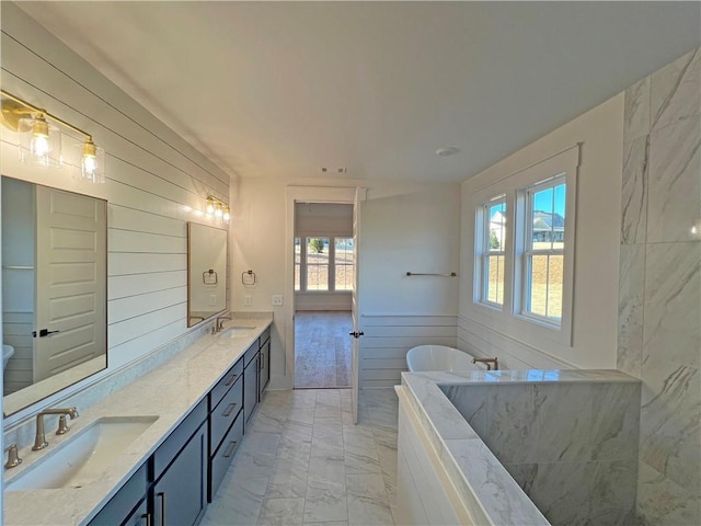 bathroom featuring a bath, a wealth of natural light, and vanity