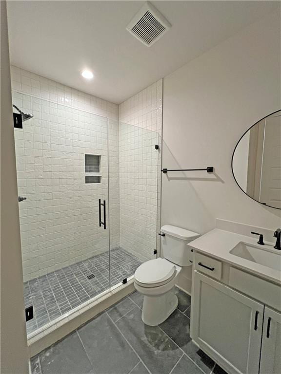 bathroom with toilet, tile patterned floors, a shower with shower door, and vanity