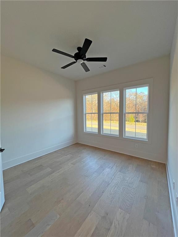 spare room with ceiling fan and light hardwood / wood-style flooring