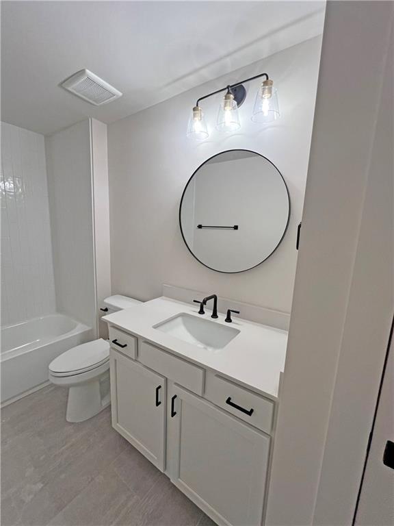 full bathroom with bathtub / shower combination, vanity, and toilet