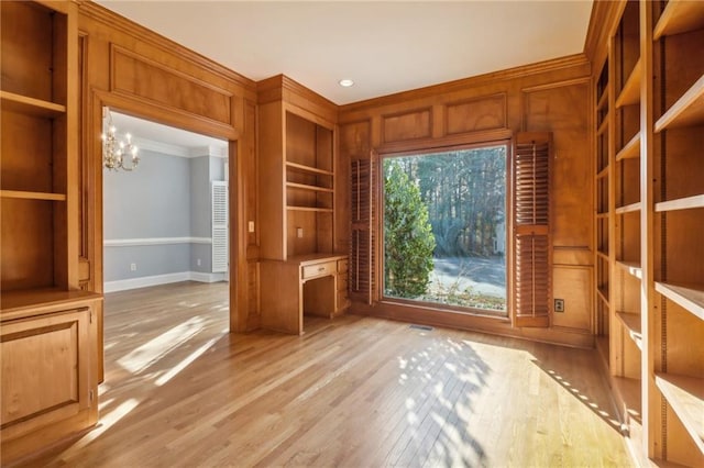 interior space with ornamental molding, light hardwood / wood-style floors, and an inviting chandelier