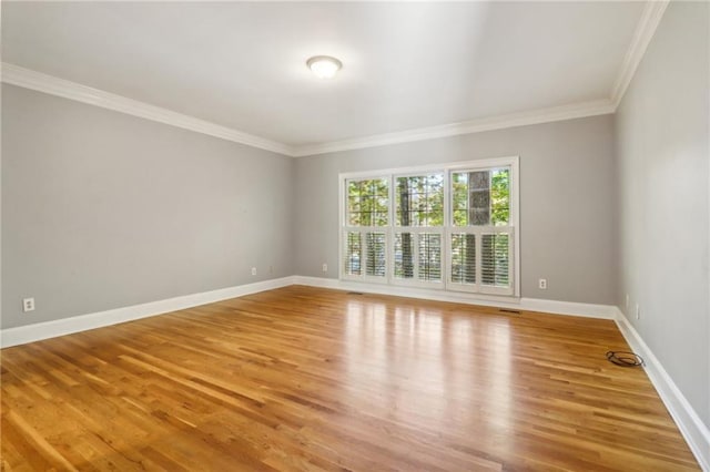 spare room featuring ornamental molding and hardwood / wood-style flooring