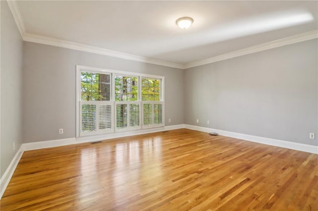 spare room with crown molding and light hardwood / wood-style floors