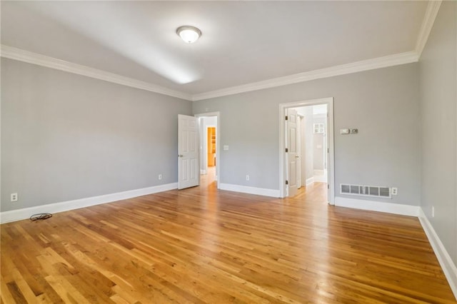 spare room with ornamental molding and light hardwood / wood-style flooring