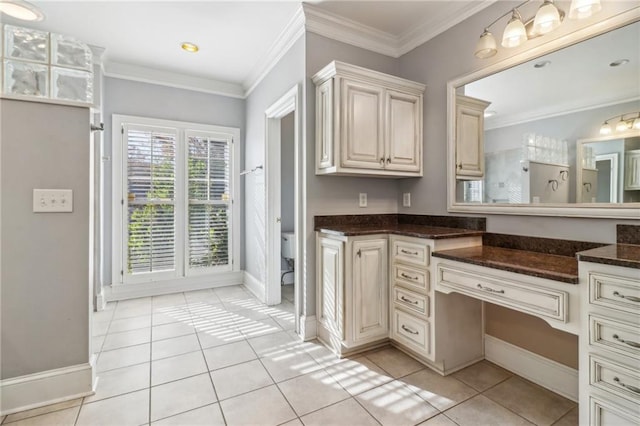 bathroom featuring tile patterned floors, crown molding, vanity, and toilet