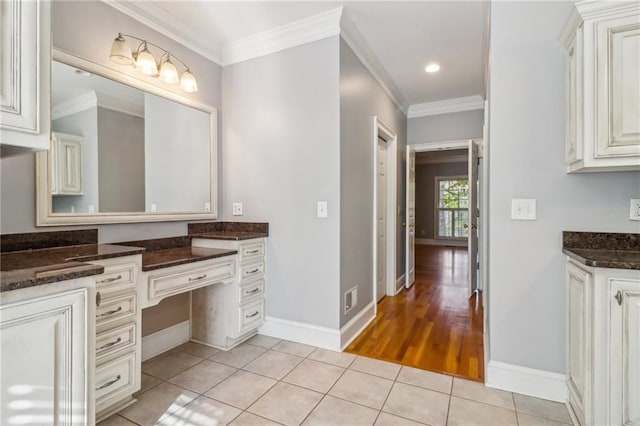 bathroom featuring tile patterned flooring, vanity, and crown molding