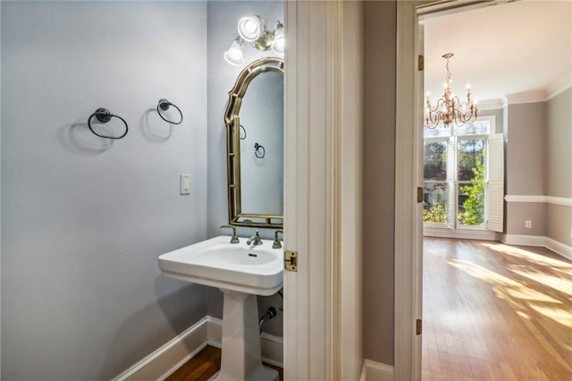 bathroom featuring hardwood / wood-style floors, a chandelier, and ornamental molding