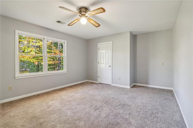 spare room featuring light carpet and ceiling fan
