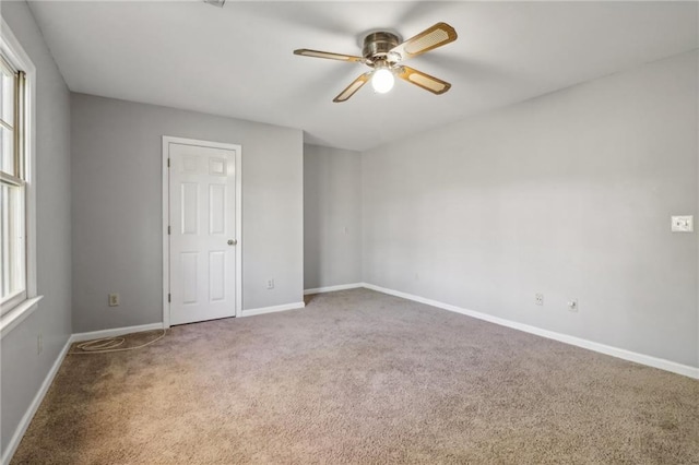 carpeted spare room with ceiling fan