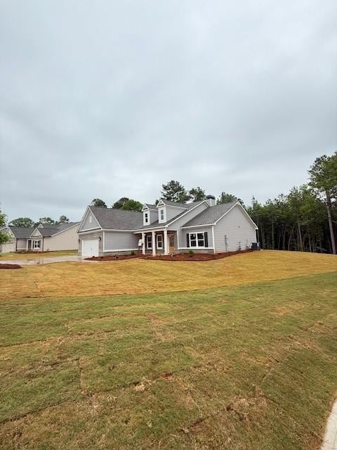 view of front of home featuring an attached garage, a front lawn, and driveway