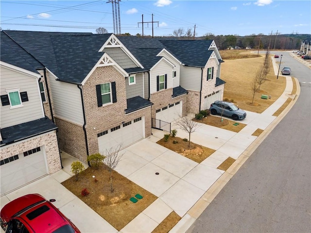 view of front of house with an attached garage, driveway, and brick siding