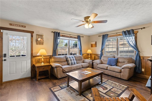 living room with a textured ceiling, dark hardwood / wood-style floors, and ceiling fan