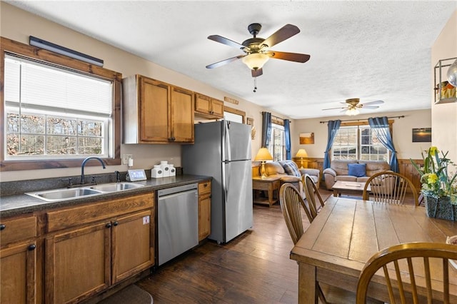 kitchen with sink, dark wood-type flooring, ceiling fan, stainless steel appliances, and a textured ceiling