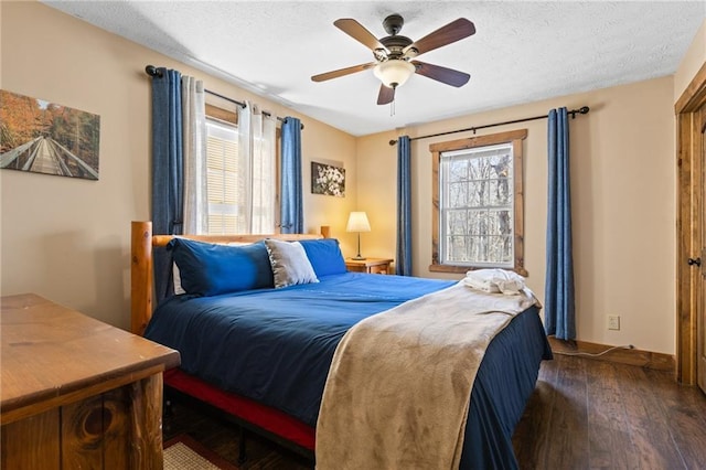 bedroom featuring dark hardwood / wood-style floors, multiple windows, and a textured ceiling