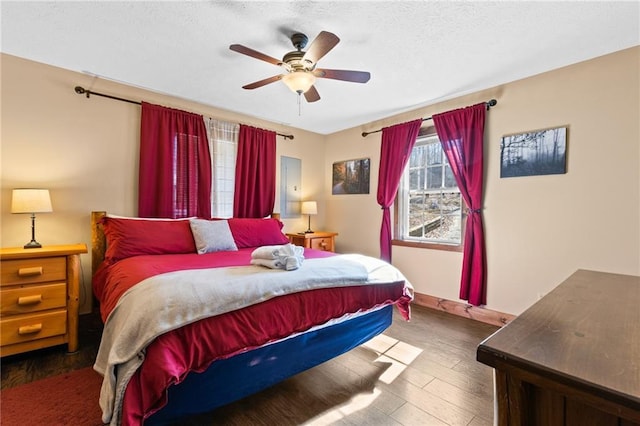 bedroom with dark hardwood / wood-style flooring and ceiling fan