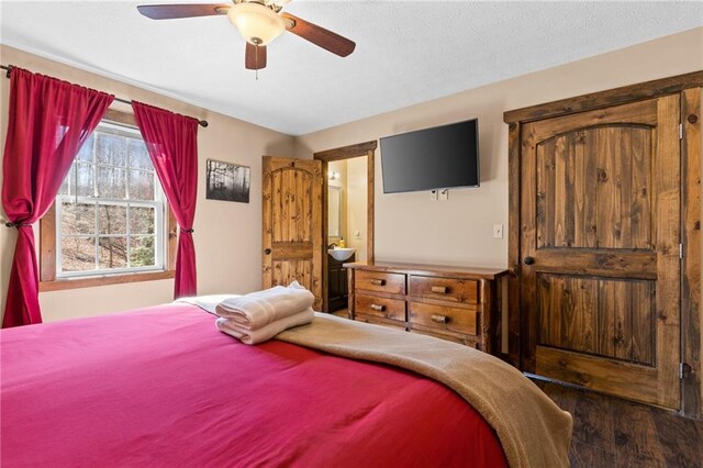 bedroom with dark hardwood / wood-style flooring, connected bathroom, and ceiling fan