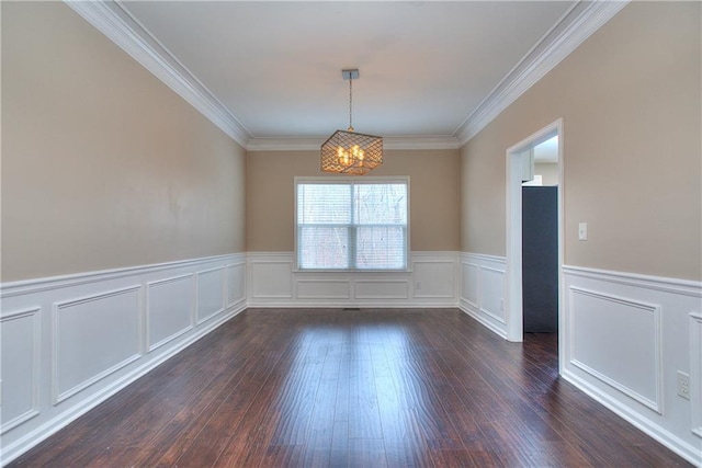 unfurnished room featuring dark hardwood / wood-style flooring, an inviting chandelier, and ornamental molding