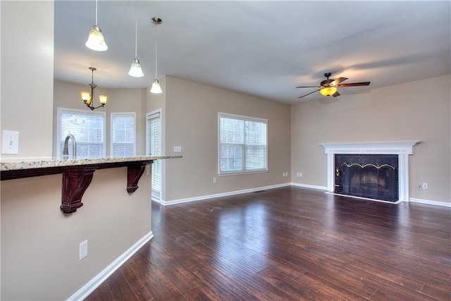 unfurnished living room featuring a wealth of natural light, dark hardwood / wood-style flooring, and a fireplace