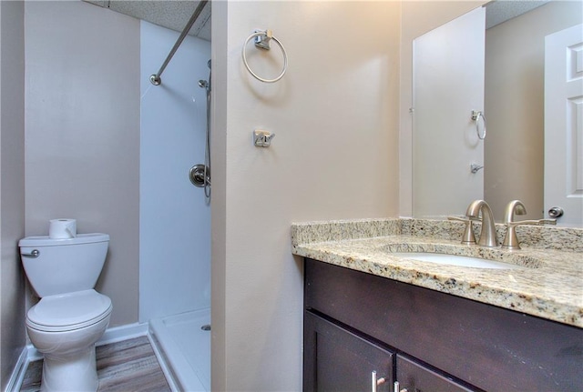 bathroom with a shower, hardwood / wood-style flooring, toilet, and vanity