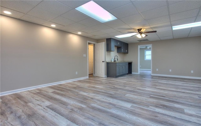 unfurnished living room featuring light hardwood / wood-style floors, a paneled ceiling, and ceiling fan