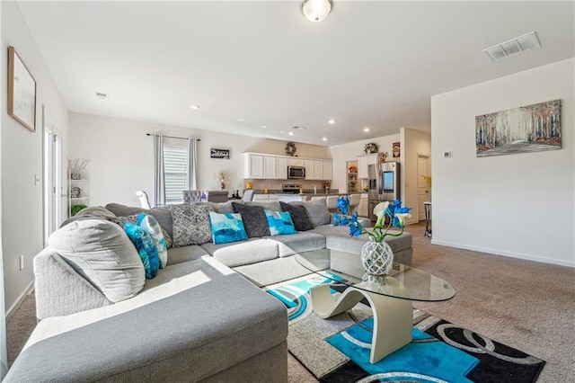 living area with recessed lighting, baseboards, visible vents, and light colored carpet