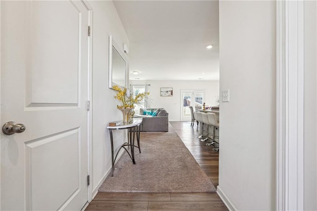 corridor with wood finished floors and baseboards