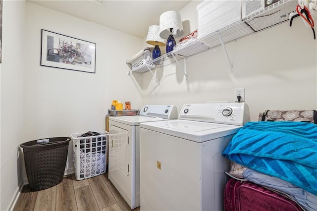 washroom with laundry area, baseboards, washer and clothes dryer, and light wood finished floors