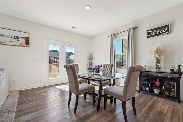 dining space with a healthy amount of sunlight, baseboards, visible vents, and dark wood finished floors