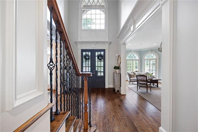 entrance foyer featuring a high ceiling, dark hardwood / wood-style flooring, french doors, and a notable chandelier