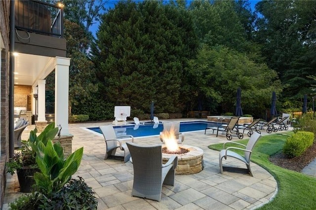 view of pool with an outdoor fire pit and a patio