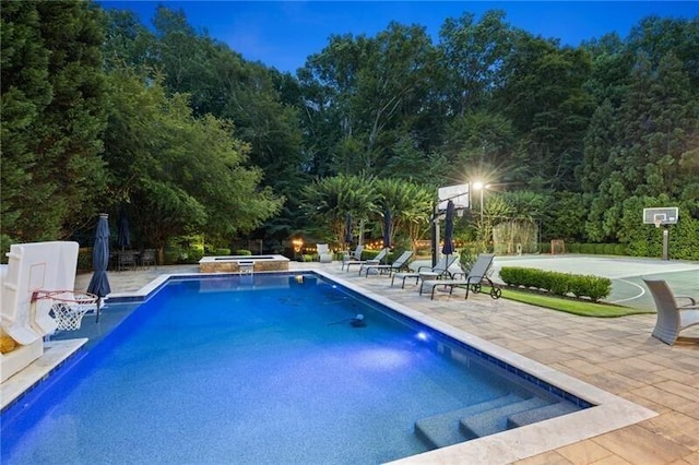 view of pool with a patio, an in ground hot tub, and basketball hoop