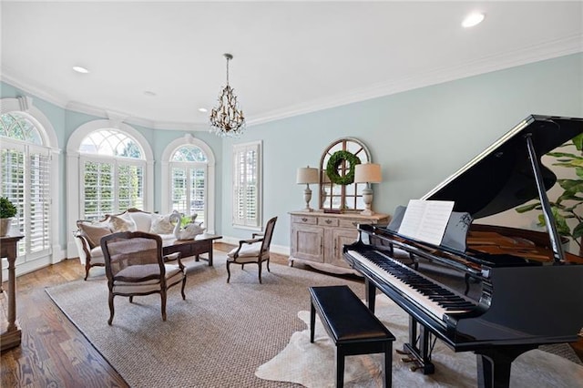 sitting room with an inviting chandelier, ornamental molding, and light wood-type flooring