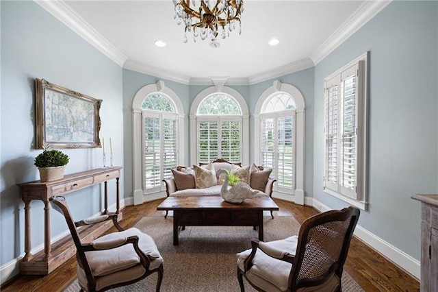 living area featuring ornamental molding, a notable chandelier, and hardwood / wood-style flooring