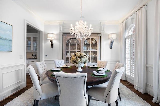 dining room with ornamental molding, dark hardwood / wood-style flooring, and a notable chandelier