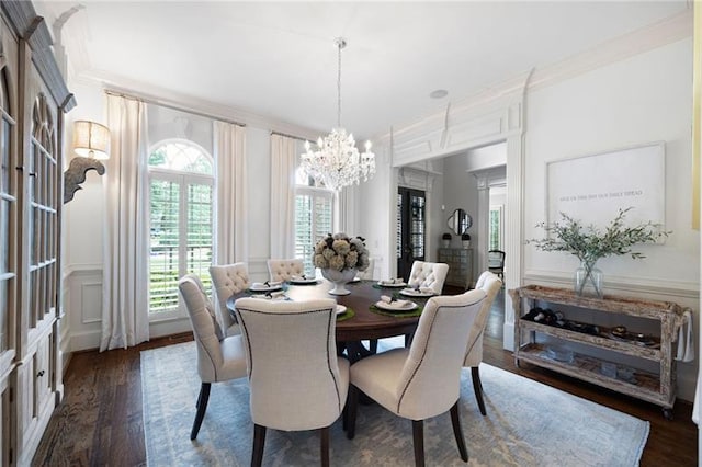 dining area featuring an inviting chandelier, crown molding, and dark hardwood / wood-style floors