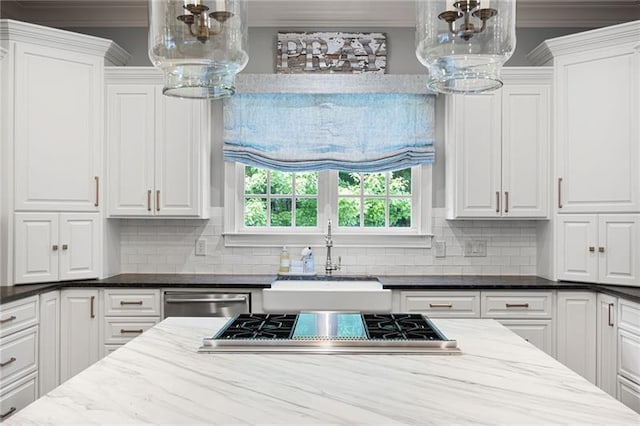 kitchen with stainless steel appliances, crown molding, dark stone counters, white cabinets, and sink